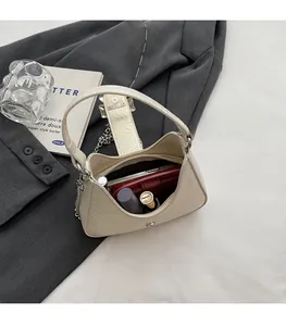 Vue intérieure d'un sac hobo crème à motif crocodile avec téléphone et rouge à lèvres