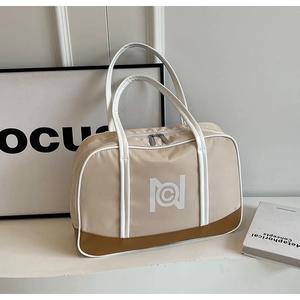 Detail view of large beige canvas tote bag with white logo and dual silver zippers