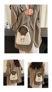 Détails du sac crème avec un grand nœud argenté et une finition texturée chic