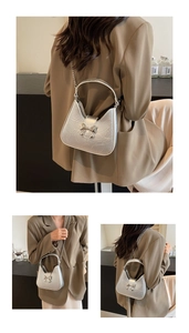 Détails du sac selle argenté métallisé avec boucle nœud et bandoulière chaîne