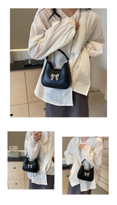 Détail du sac à main en cuir plissé noir avec grand nœud argenté et bandoulière