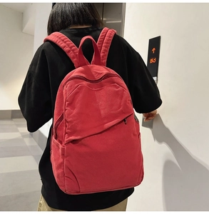 Close-up of red canvas backpack showing durable texture and reinforced shoulder straps