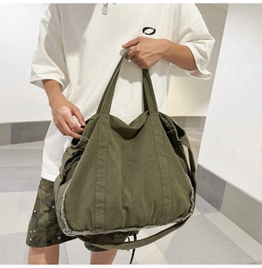 Detail of army green canvas tote bag featuring vintage raw edge stitching and thick fabric