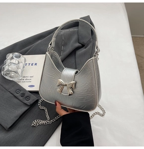Vue détaillée du sac croissant argenté avec texture plissée et boucle en nœud