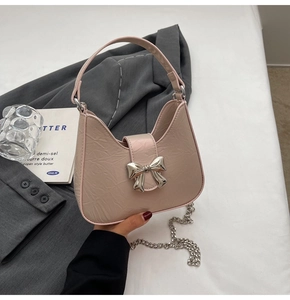 Détail du sac croissant plissé rose avec boucle nœud argentée et bandoulière en chaîne