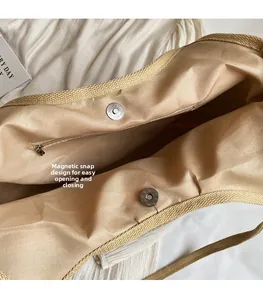 Detail of straw tote bag showing magnetic snap closure and internal zipper pocket