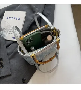 Detail view of denim bucket bag with bamboo handle and silver strap interior storage