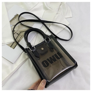 Detail view of transparent jelly beach bag with OWU logo and black leather trim accents