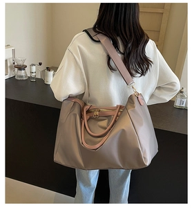 Vue détaillée du sac de voyage grande capacité avec texture nylon lisse et anses roses