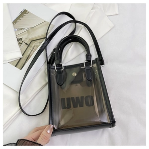 Detail of transparent black PVC bag with UWU logo, handle and adjustable strap
