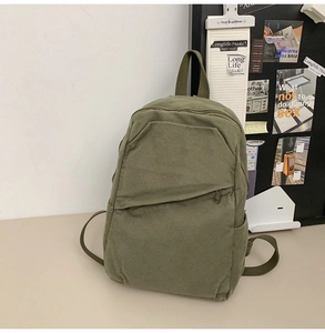 Detail of army green canvas backpack featuring wear-resistant fabric and side pocket
