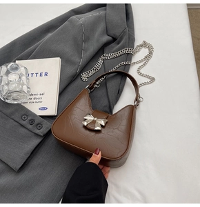 Détail du sac en cuir plissé marron foncé avec boucle nœud argenté et chaîne