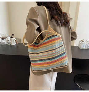 Detail of colorful striped straw tote bag worn over the shoulder for beach or summer style