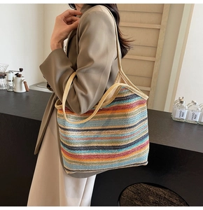 Detailed texture of a colorful striped straw tote bag with woven shoulder strap