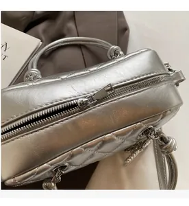 Detailed macro view of smooth silver metal zipper and quilted pattern on hand bag