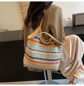 Detailed close-up of colorful striped woven tote bag with a beige wide shoulder strap