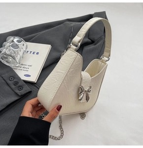 Détail du sac croissant blanc cassé avec nœud en métal argenté et bandoulière