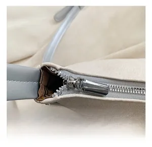 Detail of silver zipper and beige leather texture with striped lining on a shoulder bag