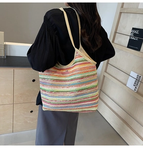 Detailed close-up of a large multi-color striped woven tote bag with a magnetic buckle
