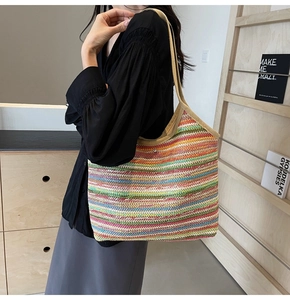 Close-up of colorful striped straw tote bag with fine woven texture and metal clasp