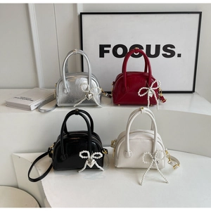 Détails des mini sacs Boston avec nœuds en perles et breloques en forme de cœur