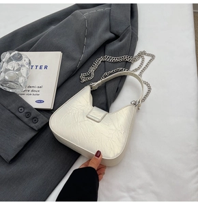Détail du sac hobo blanc montrant la texture plissée et l'élégante chaîne argentée