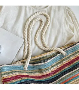 Detail of colorful striped woven tote bag with durable cotton rope handles on white fabric