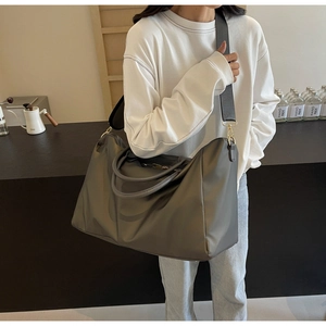 Sac de voyage gris grande capacité porté par une personne pour le week-end et sport