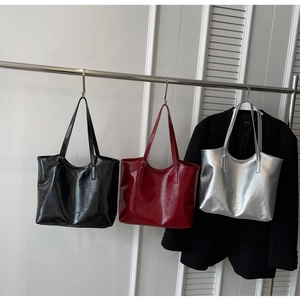 Close-up of large capacity tote bags in black, red, and silver with textured PU leather