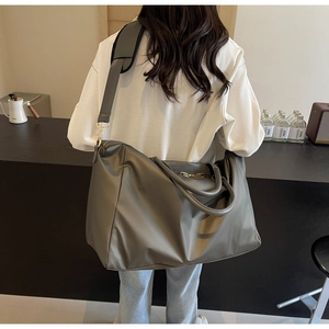 Détail du sac de voyage imperméable gris-vert avec bandoulière large et poignées solides