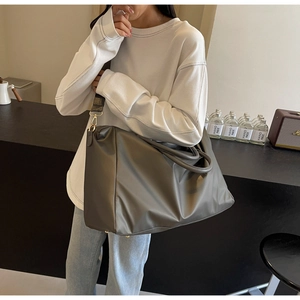 Détail du sac de voyage gris montrant le nylon imperméable et la boucle en métal doré