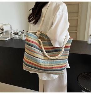 Détail du sac cabas en paille rayé coloré avec d'épaisses bretelles en coton blanc