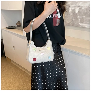 Detail of silver hobo shoulder bag featuring colorful 3D heart motifs and double straps