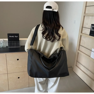 Détail du grand sac de voyage noir avec bandoulière réglable et nylon résistant