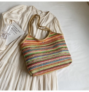 Top-down view of a colorful striped woven straw tote bag with silver metal clasp detail