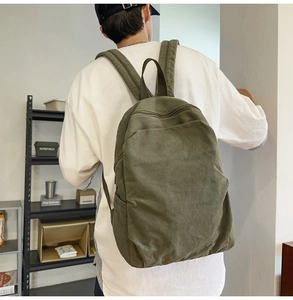 Close-up of olive green canvas backpack on model showing durable material and casual style