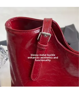 Detail of red wax leather tote showing silver buckle and vintage texture stitching