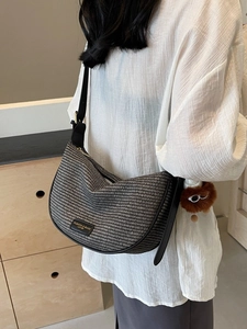 Minimalist woven dumpling shoulder bag with adjustable strap and cute plush charm