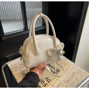 Détail du sac Boston en cuir plissé blanc avec nœud en perles et finitions dorées