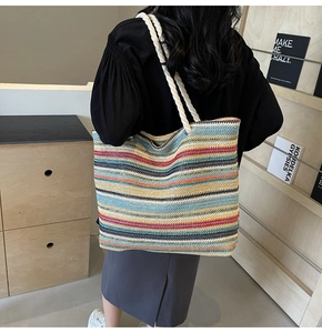 Détail d'un grand sac cabas tissé à rayures colorées avec des anses en corde blanche bohème