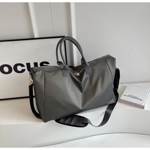 Détail du sac de voyage gris foncé avec fermetures dorées et bandoulière réglable