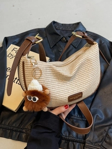 Woven half-moon dumpling bag in beige with brown leather trim and cute plush charm