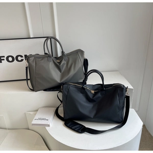 Vue détaillée de grands sacs de voyage noir et gris avec fermetures éclair dorées et sangles