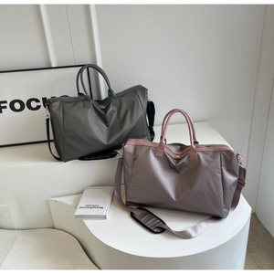 Gros plan de grands sacs de voyage vert-gris et roses avec bandoulières réglables chic