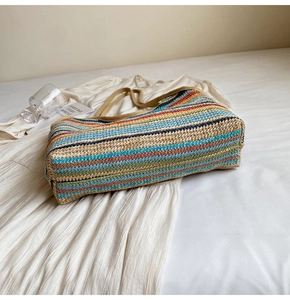 Macro view of textured colorful striped straw tote bag weave and durable brown strap