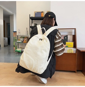 Detail view of the wide padded shoulder straps on a minimalist canvas backpack for women