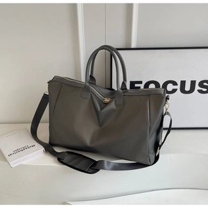 Détail du sac de voyage gris foncé avec fermetures dorées et bandoulière réglable