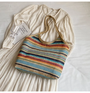 Close-up of colorful striped straw tote bag showing woven texture and snap closure