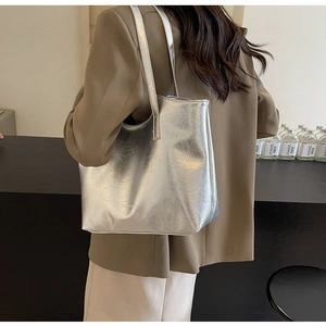 Silver metallic tote bag with wrinkled texture shown on shoulder for a stylish look