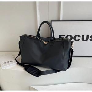 Détail du sac de voyage noir multifonctionnel avec fermetures éclair dorées et sangle